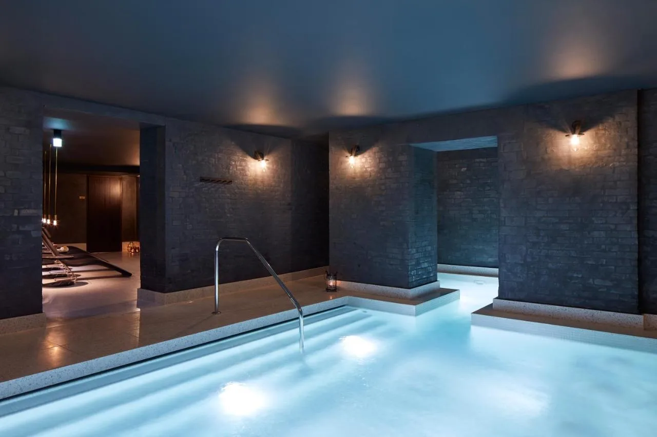 Large illuminated indoor swimming pool at St. James' Court, A Taj Hotel, London