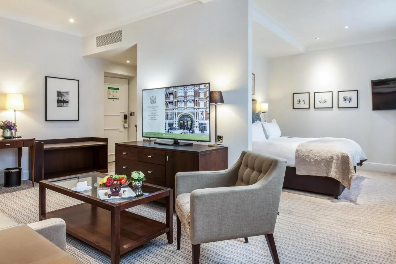 Hotel room with a king bed and television at St. James' Court, A Taj Hotel, London